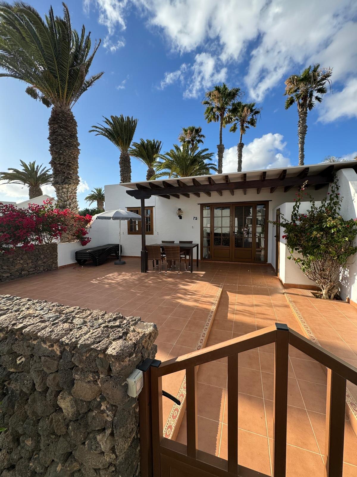 Villa 73 exterior with south-facing patio and dining set